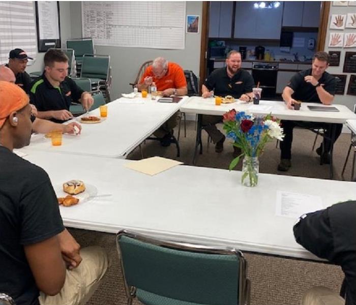 SERVPRO team members sitting around table eating breakfast