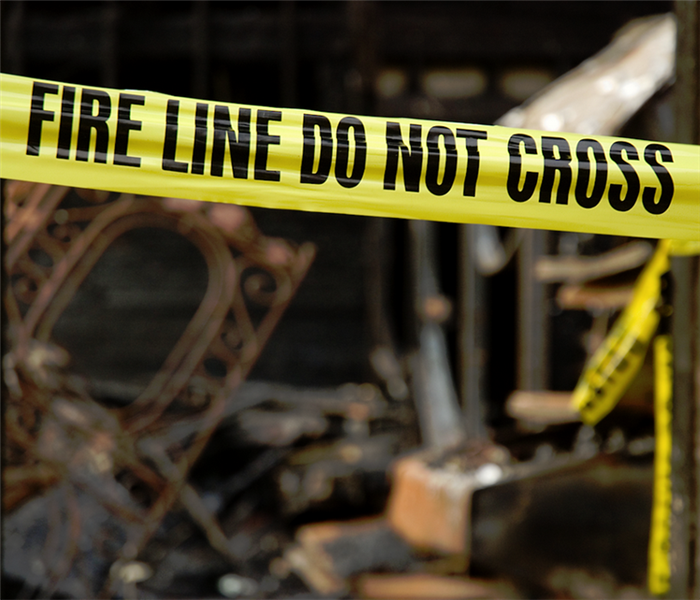 a fire damaged house with yellow fire tape