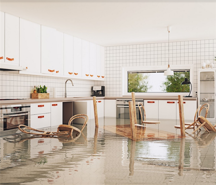 a flooded kitchen with the dining table and chairs floating around